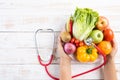 Healthy lifestyle, food and nutrition concept. Close up doctor woman hand holding plate of fresh vegetables and fruits with Royalty Free Stock Photo