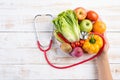 Healthy lifestyle, food and nutrition concept. Close up doctor woman hand holding plate of fresh vegetables and fruits with Royalty Free Stock Photo