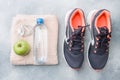 Healthy lifestyle, food and water, athlete`s equipment on grey background. Flat lay. Top view with copy space Royalty Free Stock Photo