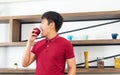 Healthy lifestyle and freshness concept. Smart, young and healthy Asian man eating apple in the loft style kitchen room Royalty Free Stock Photo