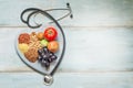 Healthy lifestyle and healthcare concept with food, heart and stethoscope