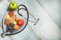 Healthy lifestyle and healthcare concept with food, heart and stethoscope Royalty Free Stock Photo