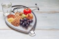 Healthy lifestyle and healthcare concept with food, heart and stethoscope Royalty Free Stock Photo