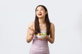 Healthy lifestyle, leisure and people emotions concept. Gorgeous happy asian girl smiling and laughing while eating Royalty Free Stock Photo