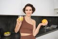 Healthy lifestyle and sport. Beautiful smiling woman, drinking fresh orange juice and holding fruit in her hand Royalty Free Stock Photo