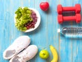 Healthy lifestyle sport equipment fitness, sneakers, green apple, fresh water and healthy food on blue wood background Royalty Free Stock Photo