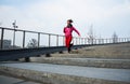 Healthy lifestyle sports woman running up on stone stairs at sunrise seaside Royalty Free Stock Photo