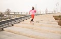 Healthy lifestyle sports woman running up on stone stairs at sunrise seaside Royalty Free Stock Photo