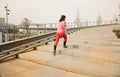 Healthy lifestyle sports woman running up on stone stairs at sunrise seaside Royalty Free Stock Photo