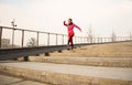 Healthy lifestyle sports woman running up on stone stairs at sunrise seaside Royalty Free Stock Photo