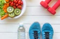 Healthy lifestyle for women diet with sport equipment, sneakers, measuring tape, vegetable fresh and bottle of water on wooden. Royalty Free Stock Photo