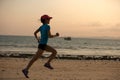 young fitness woman running at sunset beach Royalty Free Stock Photo