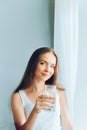 Healthy lifestyle.Young woman drinking from a glass of  fresh water. Healthcare. Drinks. Portrait of happy smiling female model ho Royalty Free Stock Photo