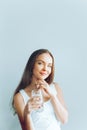 Healthy lifestyle. Young woman show glass of water. Girl drinks water. Portrait of happy smiling female model  holding transparent Royalty Free Stock Photo