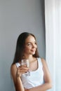 Healthy lifestyle. Young woman show glass of water. Girl drinks water. Portrait of happy smiling female model Royalty Free Stock Photo