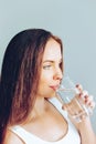 Healthy lifestyle. Young woman show glass of water. Girl drinks water. Portrait of happy smiling female model  holding transparent Royalty Free Stock Photo