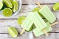 Lime yogurt ice pops, top view table scene over white wood Royalty Free Stock Photo