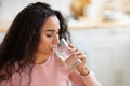 Healthy Liquid. Beautiful Brunette Woman Drinking Mineral Water From Glass In Kitchen Royalty Free Stock Photo