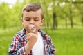 Healthy little boy blowing on dandelions outdoors Royalty Free Stock Photo