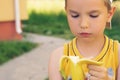 Healthy little boy eating banana. Happy kid enjoy eating fresh fruit.