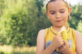 Healthy little boy eating banana. Happy kid enjoy eating fresh fruit.