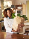 Healthy living begins at home. Portrait of a happy young woman holding a bag full of healthy vegetables at home. Royalty Free Stock Photo