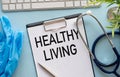Healthy Living text on blue blackboard with stethoscope and keyboard, pen Royalty Free Stock Photo