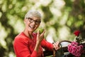 Senior woman with grey hair holding apple outside in the park Royalty Free Stock Photo