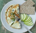 Low fat breakfast plate with egg white omelet, fiber crispbread and sliced green apple