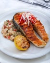 Healthy lunch bowl with grilled salmon, quinoa, and vegetables. Delicious salmon steak on table served with quinoa. Royalty Free Stock Photo