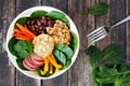 Healthy lunch bowl with quinoa, hummus, mixed vegetables, over rustic wood Royalty Free Stock Photo