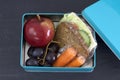 Healthy lunch box, cheese sandwich, apple, carrots and grapes