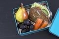 Healthy lunch box, cheese sandwich, pear, carrots and grapes