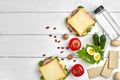 Healthy lunch box with sandwiches, eggs and fresh vegetables, bottle of water and nuts on rustic wooden background. Top Royalty Free Stock Photo