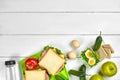 Healthy lunch box with sandwiches, eggs and fresh vegetables, bottle of water on rustic wooden background. Top view with Royalty Free Stock Photo