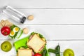 Healthy lunch box with sandwiches, eggs and fresh vegetables, bottle of water on rustic wooden background. Top view with Royalty Free Stock Photo