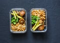 Healthy lunch box - spicy couscous with chickpeas, broccoli, green beans and turkey meatballs on dark background, top view.