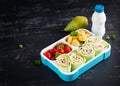 Healthy lunch box with tortilla wraps, tomatoes, banana.