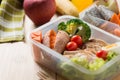 Healthy lunch boxes in plastic package, Grilled chicken breast with sweet potato, egg and vegetable salad, fruit, orange juice.