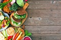 Healthy lunch food side border with nutritious hearty bowl, sandwiches, lettuce wraps and vegetables, top view over a wood backgro Royalty Free Stock Photo