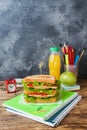 Healthy lunch for school with sandwich, fresh apple and orange juice. Assorted colorful school supplies. Copy space Royalty Free Stock Photo