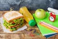 Healthy lunch for school with sandwich, fresh apple and orange juice. Assorted colorful school supplies. Copy space Royalty Free Stock Photo