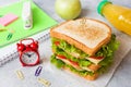 Healthy lunch for school with sandwich, fresh apple and orange juice. Assorted colorful school supplies. Copy space Royalty Free Stock Photo