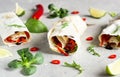 Healthy lunch snack. Three vegan tortilla wraps, rolls sandwiches with vegetable, green salad mix, lime and chili pepper