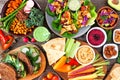 Healthy lunch table scene with nutritious Buddha bowl, lettuce wraps, vegetables, sandwiches and salad, above view over wood Royalty Free Stock Photo