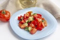 Healthy lunch, vegetable salad in a blue plate, tomato and olive oil in a bottle