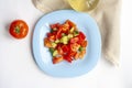 Healthy lunch, vegetable salad in a blue plate, tomato and olive oil in a bottle, top view