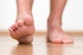 Healthy male feet stepping over home-like