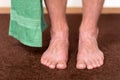 Healthy male feet with towel stepping towards