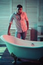 Healthy man in bathroom, health concept. Healthy macho in shirt and jeans ready to bath